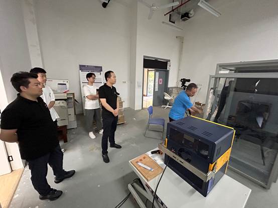 A group of men standing in a room
Description automatically generated